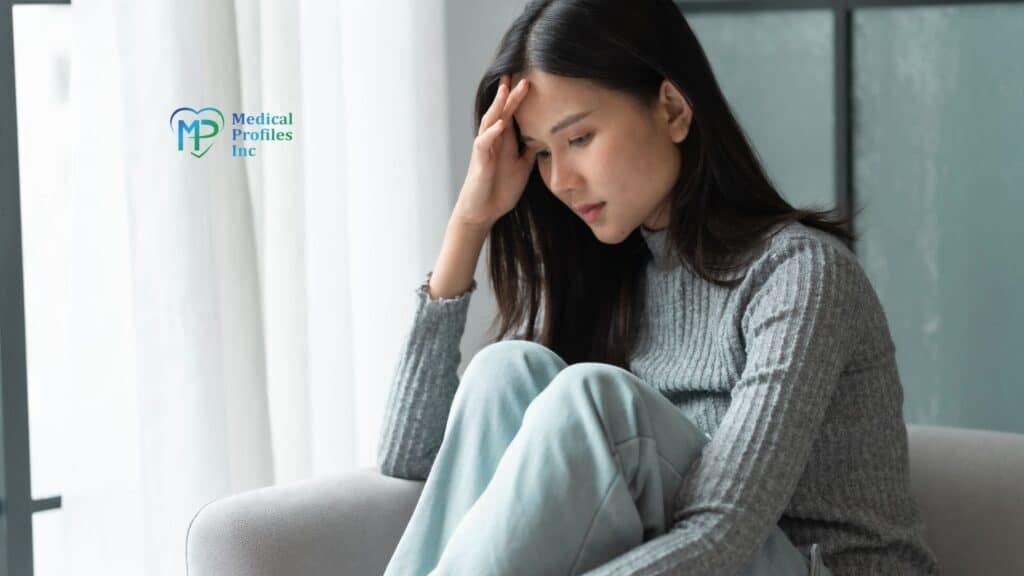 A woman on sofa touching her forehead