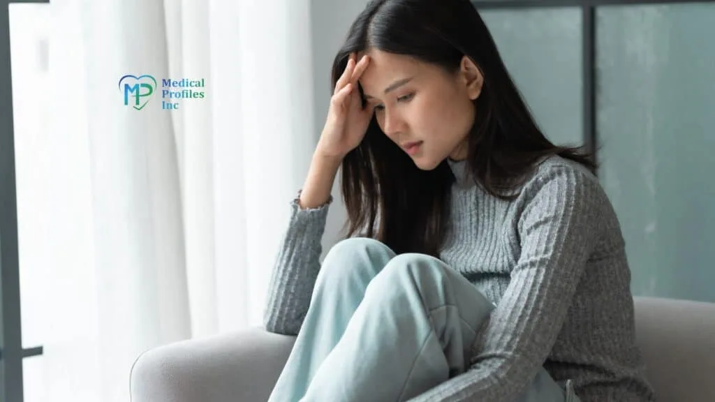 A woman on sofa touching her forehead